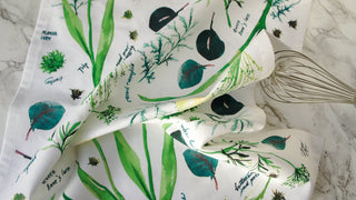 Green Botanical Tea Towel with Jean Choe's watercolor botanical artwork including tulips, eucalyptus, and other greenery