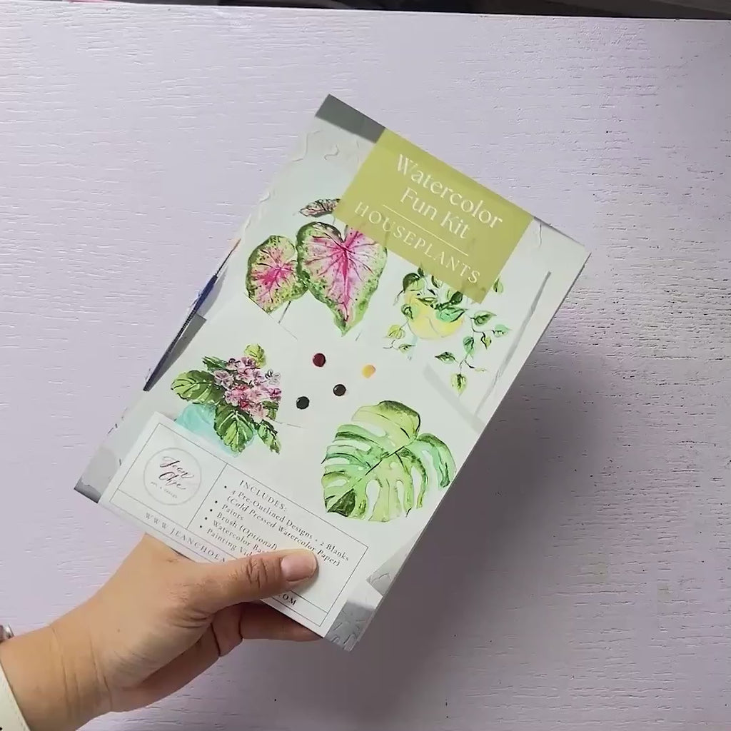 Video showing Jean Choe's watercolor fun kit for Houseplants, with pre-outlined pages, a paint dot card and a brush.